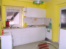 Kuchyně s varným panelem, ledničkou, varnou konvicí a pračkou
