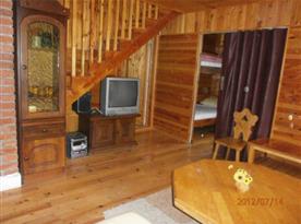 Obývací pokoj s televizí a schody do podkroví