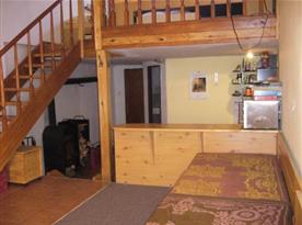 Obývací pokoj s pohovkou a schody na podestu