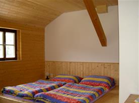 Pokoj obložený dřevem v podkroví