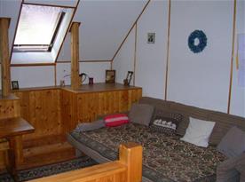 Podkrovní obývací pokoj s televizí