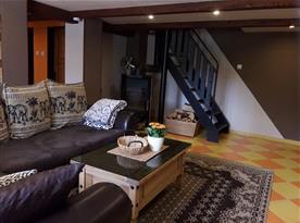 Obývací pokoj s jídelním koutem, krbem a schody do patra