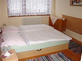 Pokoj s manželskou postelí, nočními stolky a lampičkami