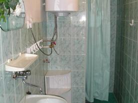 Koupelna se sprchovým koutem, umývadlem a zrcadlem